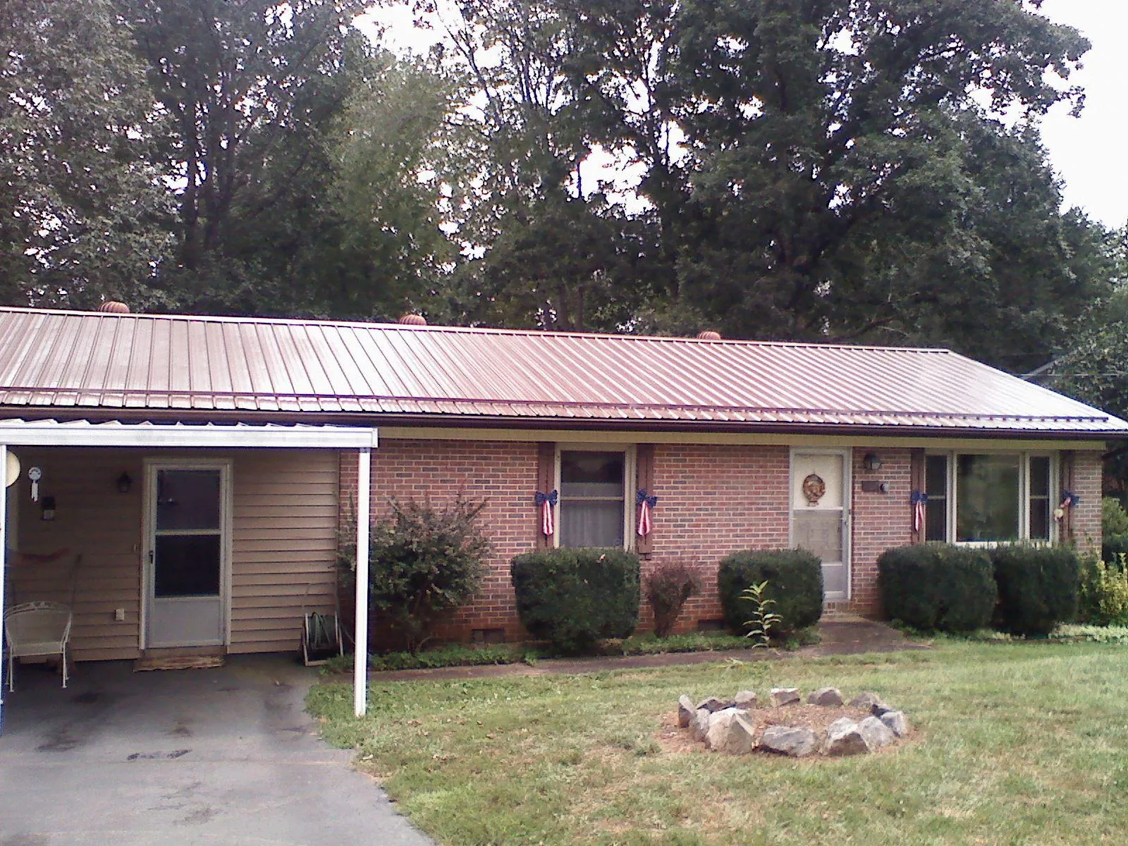 Bronze metal roof and carport on a brick ranch home — Roof Repair work by our crew in Gardner